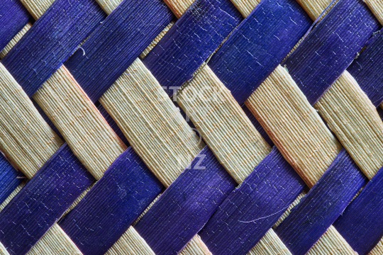 Flax weaving background - closeup of a natural and dark blue takirua weave
