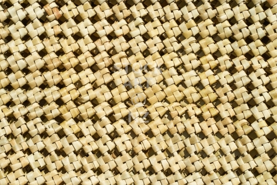 New Zealand flax weaving:  windmill knot - Closeup of a woven mat in natural colour - background