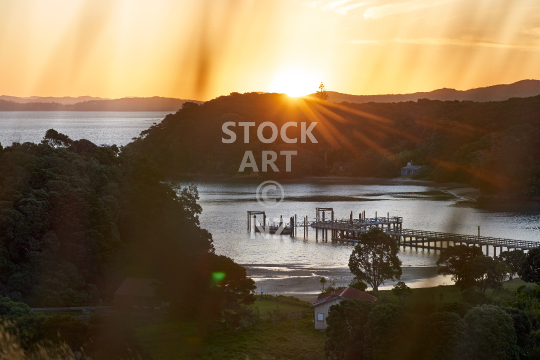 Sunset at Otehei Bay, Urupukapuka Island, Bay of Islands, Northland NZ - View through the grass from the hills above the idyllic bay