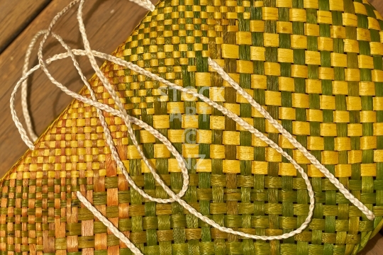 Yellow kete with white muka fibre handles